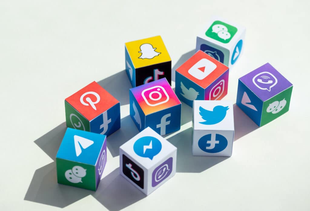 Colorful social media logo blocks representing various platforms like Facebook, Instagram, Twitter, and Snapchat, illustrating 2021 social media trends and marketing strategies.